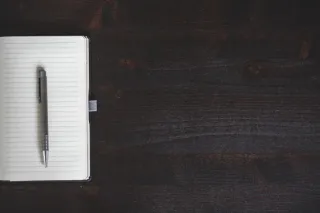 An open notebook and pen on a work desk